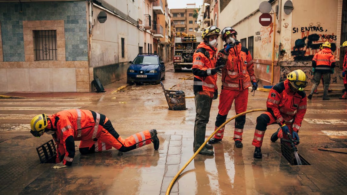 Bomberos trabajando en una calle inundada durante un juicio