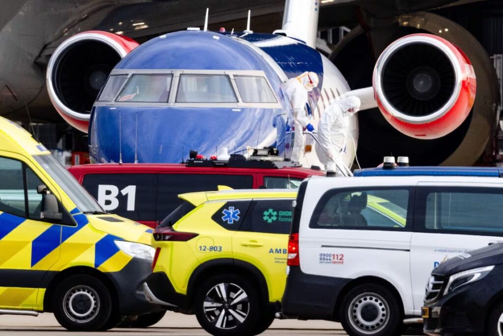 Avión en el aeropuerto con personal en trajes de protección