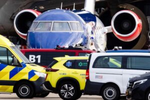 Avión en el aeropuerto con personal en trajes de protección