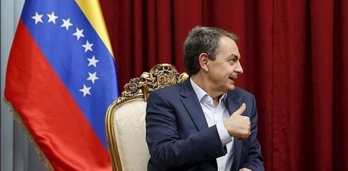 José Luis Rodríguez Zapatero en reunión con bandera de Venezuela de fondo