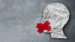 Cabeza de papel arrugado con cinta roja en la boca simbolizando censura