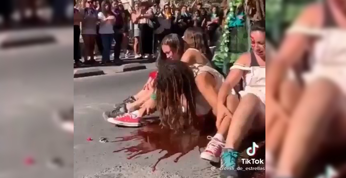 Grupo de mujeres en una manifestación con un ambiente tenso y polémico.