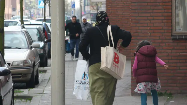 Mujer y niña caminando por la calle en Holanda con bolsas de compras.