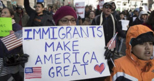 Protesta de inmigrantes con pancarta sobre su contribución a Estados Unidos