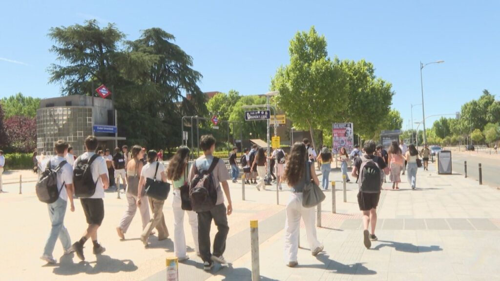 Grupo de jóvenes caminando hacia la universidad en un día soleado