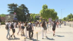 Grupo de jóvenes caminando hacia la universidad en un día soleado