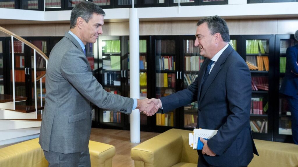 Pedro Sánchez y un político estrechándose la mano en un entorno formal