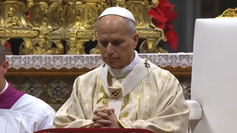 El Papa Leon en una ceremonia religiosa, con las manos juntas en oración.
