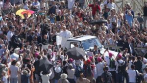 El papa León XIV saluda a la multitud desde el papamóvil en Madrid.