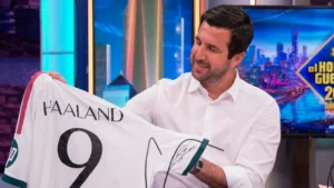Enrique Riquelme mostrando camiseta de Haaland en programa de televisión.