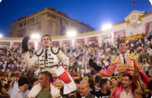 Dos toreros celebrando en una plaza llena de público al atardecer en Marbella