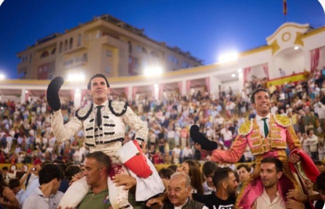 Dos toreros celebrando en una plaza llena de público al atardecer en Marbella