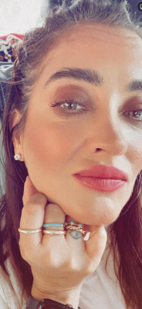 Retrato de mujer con anillos en la mano y maquillaje sutil