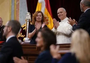 El Papa León XIV aplaudiendo en el congreso con asistentes emocionados.